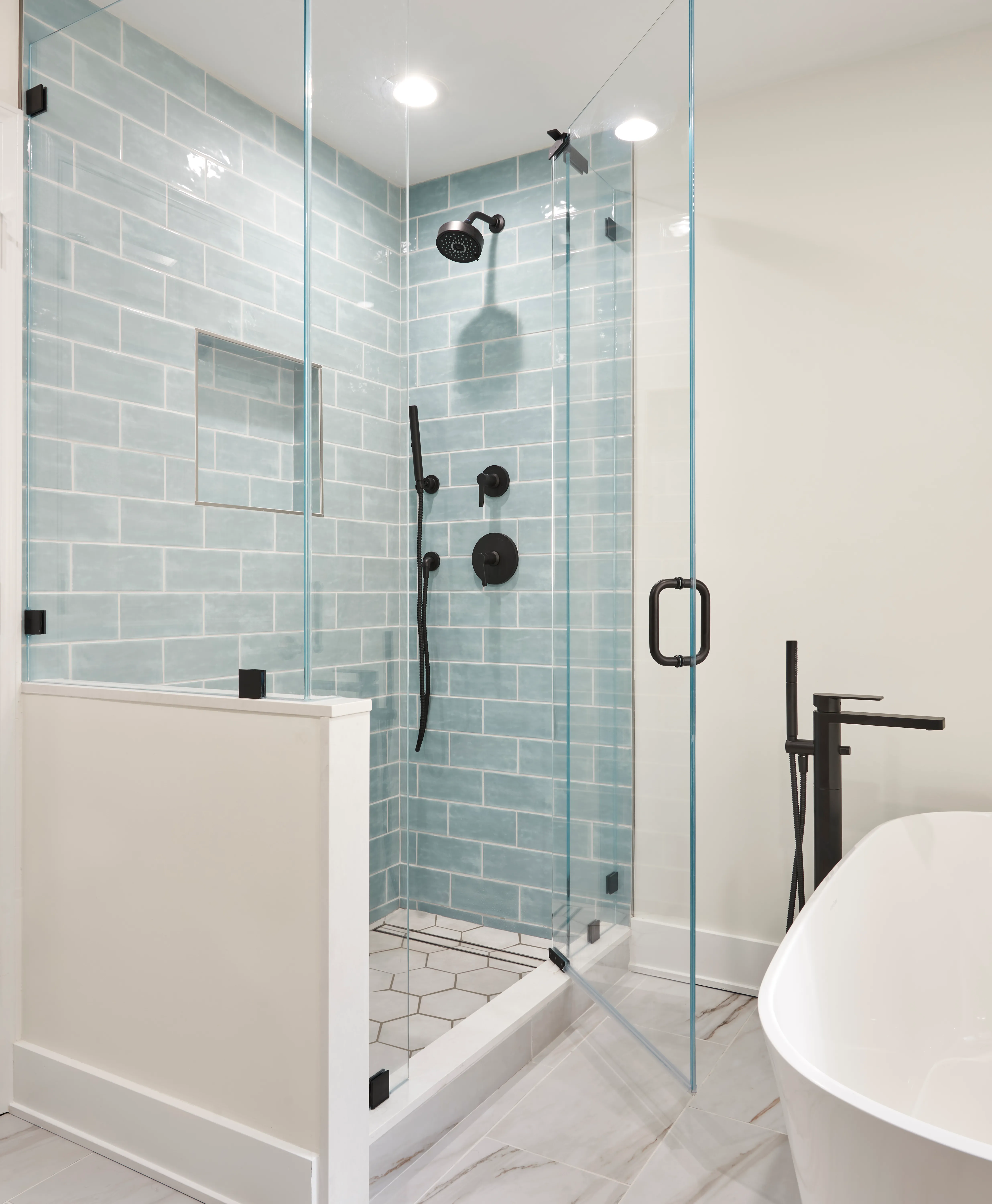 white bathroom with freestanding tub near shower