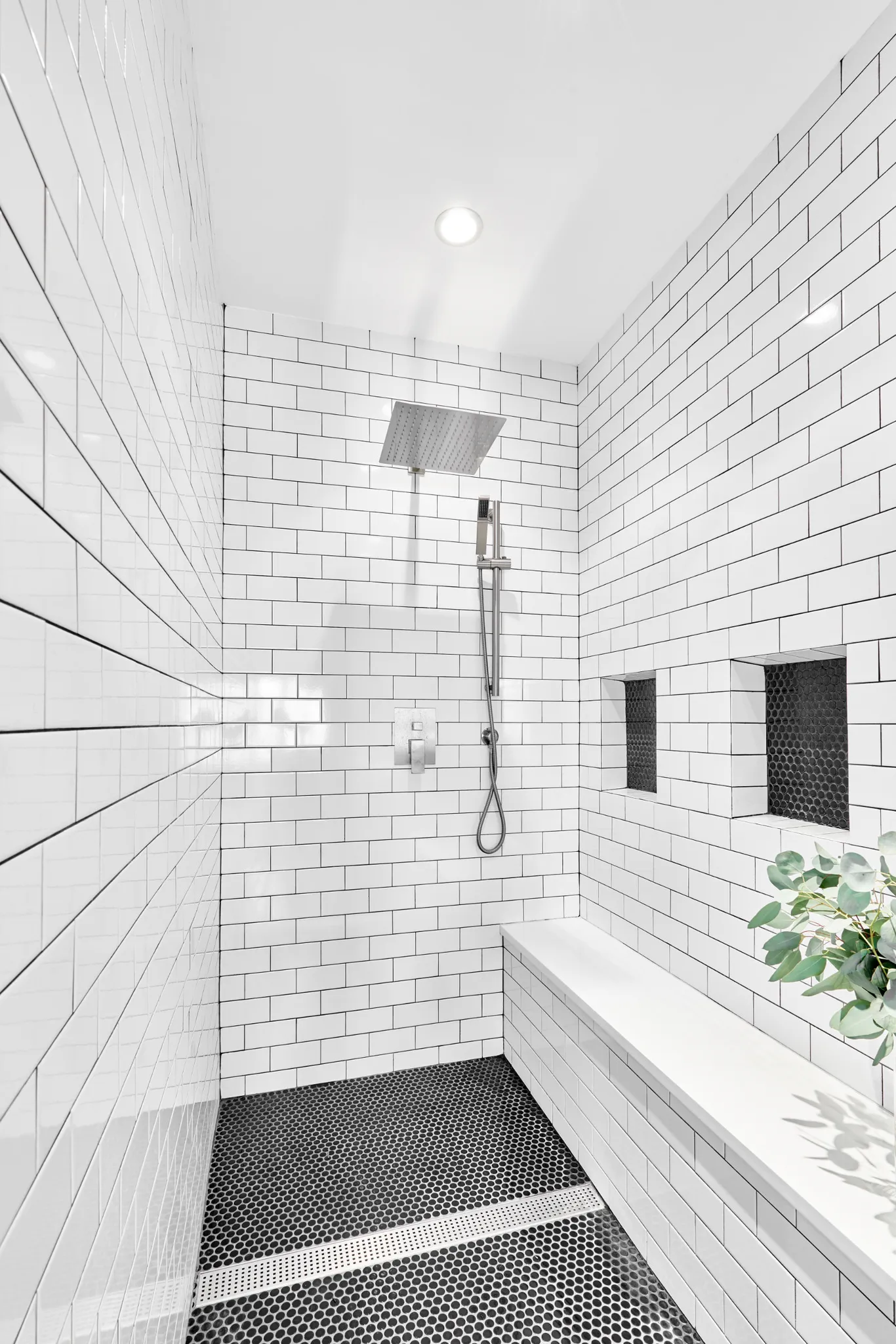 Walk-in shower with bench and white subway tile
